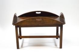 A mahogany butlers tray coffee table with four hinged sides on square tapering legs,