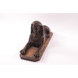 An early 19th century bronze model of an Egyptian sphinx, on a replacement wooden base,