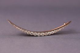 A late Victorian platinum and 18ct rose gold diamond crescent brooch set with twenty three old cut