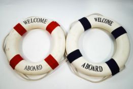 A pair of life buoys, each with applied lettering 'Welcome Aboard',