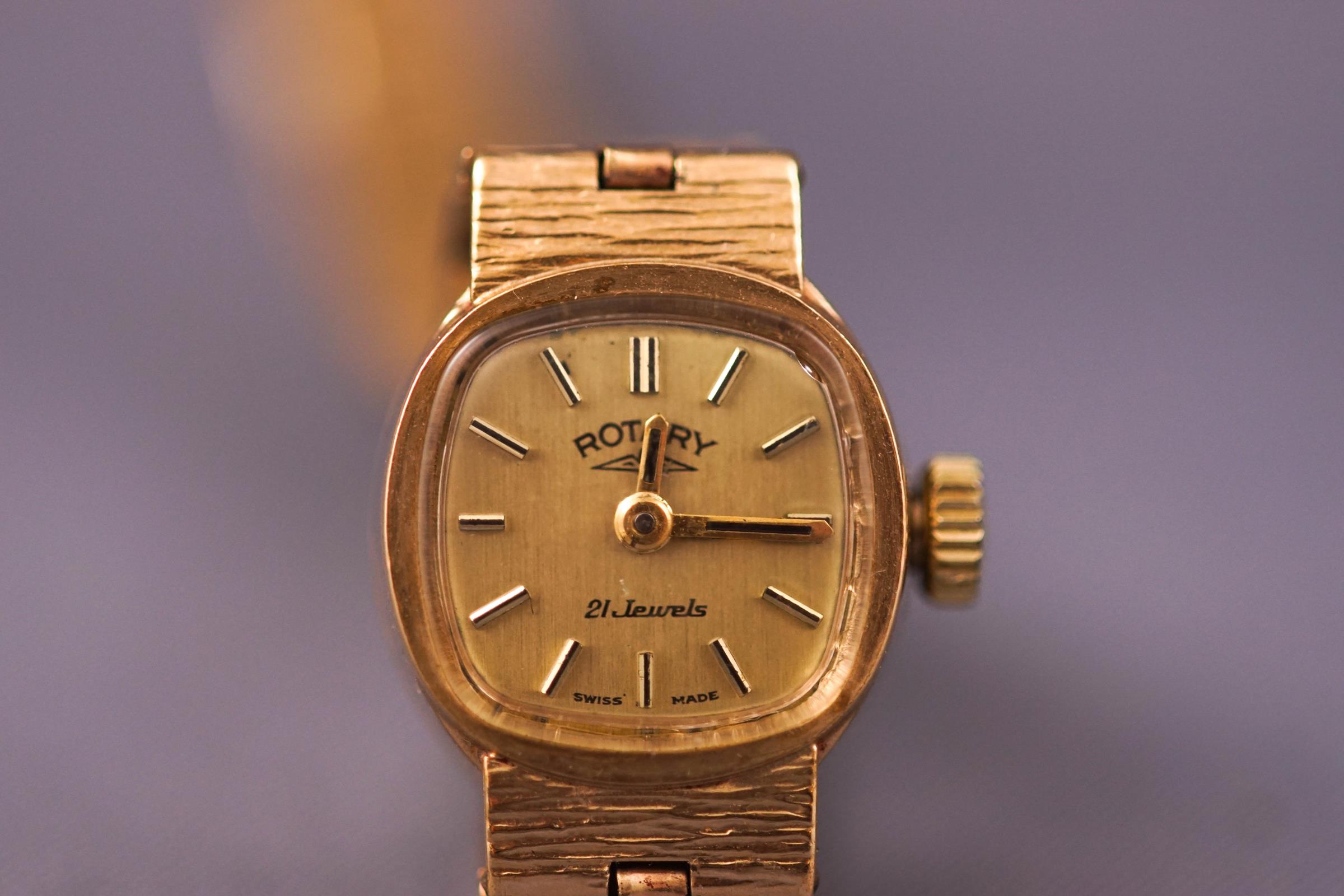 A yellow metal ladies bracelet wristwatch. Cushion gold dial with baton markings. Signed Rotary.