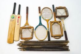 A quantity of vintage tennis racquets and presses, cricket bats,