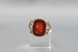 A Victorian rose gold and carnelian signet ring, carved with an elderly gentleman,