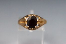 A yellow metal single stone ring set with an oval garnet. hallmarked 9ct gold, Birmingham Size: R 2.