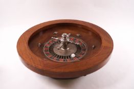 An early 20th century roulette wheel with rosewood surround,