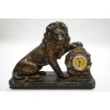 A French plaster mantel clock, modelled as a lion with its paw upon the clock,