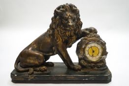 A French plaster mantel clock, modelled as a lion with its paw upon the clock,