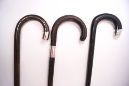 Three walking sticks with silver tips, one London 1941,