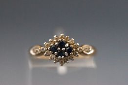 A yellow metal cluster ring set with sapphires and cubic zirconias. Hallmarked 9ct, edinbugh.