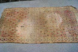 A Caucasian carpet with allover repeating motif within three borders on a red ground,