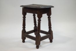 A 19th century oak joint stool with turned legs linked by square stretchers,