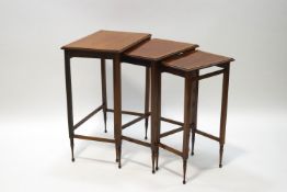 An Edwardian inlaid mahogany nest of three tables with turned feet,