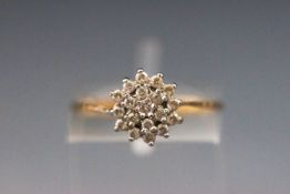 A yellow metal cluster ring set with cubic zirconia. Hallmarked 9ct gold, london.