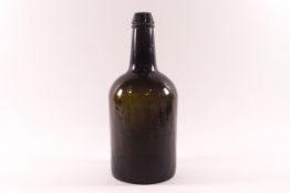 A 19th century glass wine bottle, indistinct raised lettering to base,