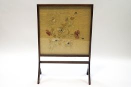 An Edwardian mahogany firescreen with raised embroidered silk flowers,
