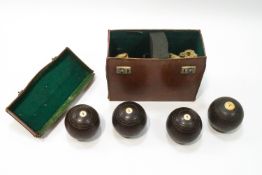 Four Edwardian bowling woods with leather case