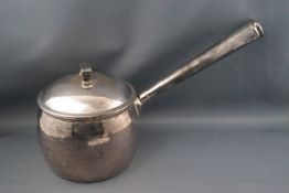 A silver saucepan and cover, with straight tapering handle, 14cm high, London 1910,