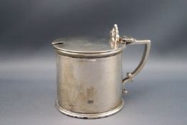 A Victorian silver mustard pot of cylindrical form with double scroll thumb rest,