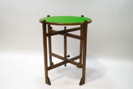 A 'Revertable' folding oak card table, the green baize top separate to the base,