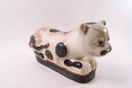 A Chinese stoneware figure of a cat with large spot decoration,