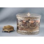 A silver plated biscuit box of oval form, the hinged cover with leaf and berry roundel,