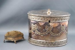 A silver plated biscuit box of oval form, the hinged cover with leaf and berry roundel,