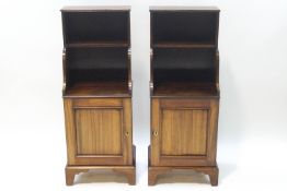 A pair of mahogany cupboards with shelves above on bracket feet,