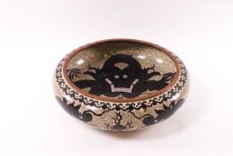 A Chinese cloisonne enamel bowl with a black dragon to the centre and further dragons to the