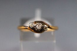 A yellow and whtie metal three stone diamond ring. tests indicate 18ct gold. Size Q 2.