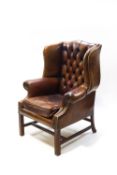 A modern brown leather Chesterfield armchair,