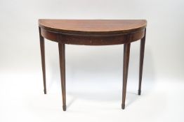 A 19th century mahogany demi lune foldover card table, with crossbanding and stringing,
