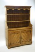 A Victorian pine dresser with two shelves over a cupboard base,
