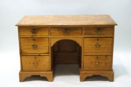 A Victorian pine kneehole desk with an arrangement of seven drawers,