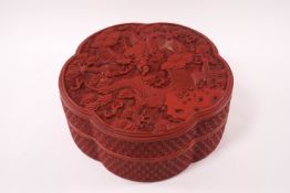 A Chinese cinnebar lacquer lobed box and cover, the lid carved with a dragon among clouds,