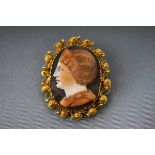 A carved onyx/shell cameo brooch with intricate yellow gold mount testing as 22ct gold Pin and