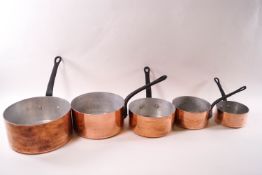A set of five copper saucepans and a further copper pan