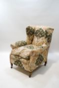 A wing back armchair on turned legs with later casters