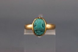 A late Victorian gold and faience scarab beetle ring, the scarab rub-over set on a plain shank,