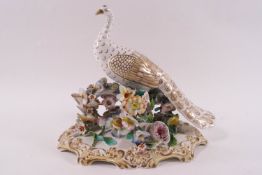 A Coalport style porcelain figure of a white peacock on a floral encrusted base,