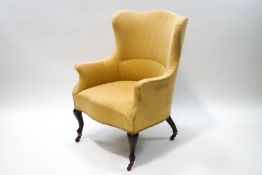 An Edwardian armchair upholstered in yellow,