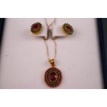 A 22ct yellow gold oval cluster pendant set with very low commecial grade rubies and emeralds.