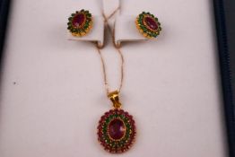 A 22ct yellow gold oval cluster pendant set with very low commecial grade rubies and emeralds.