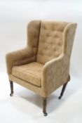 A 19th century wingback armchair on turned mahogany legs,