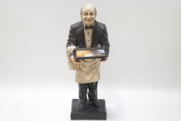A floor standing figure of a cocktail waiter holding an advertising tray,