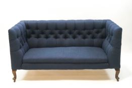 A Victorian button back sofa upholstered in petrol blue fabric on mahogny cabriole legs,