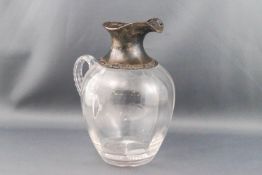 An Edwardian silver mounted clear glass ovoid decanter, the mounts with scroll pierced borders,