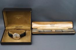 A Longines gentleman's wristwatch, round silver baton dial, black leather strap.