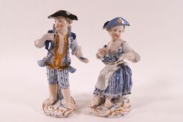 A pair of 19th century Miessen porcelain figures of a boy and girl, painted in blue and gilt,
