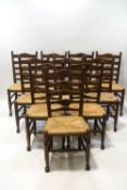 A set of ten 18th century style oak ladder back chairs with rush seats