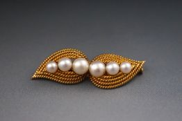 A yellow metal leaf brooch set with six graduated cultured pearls. Pin and barrel safety catch.